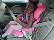 kid in car seat in pink