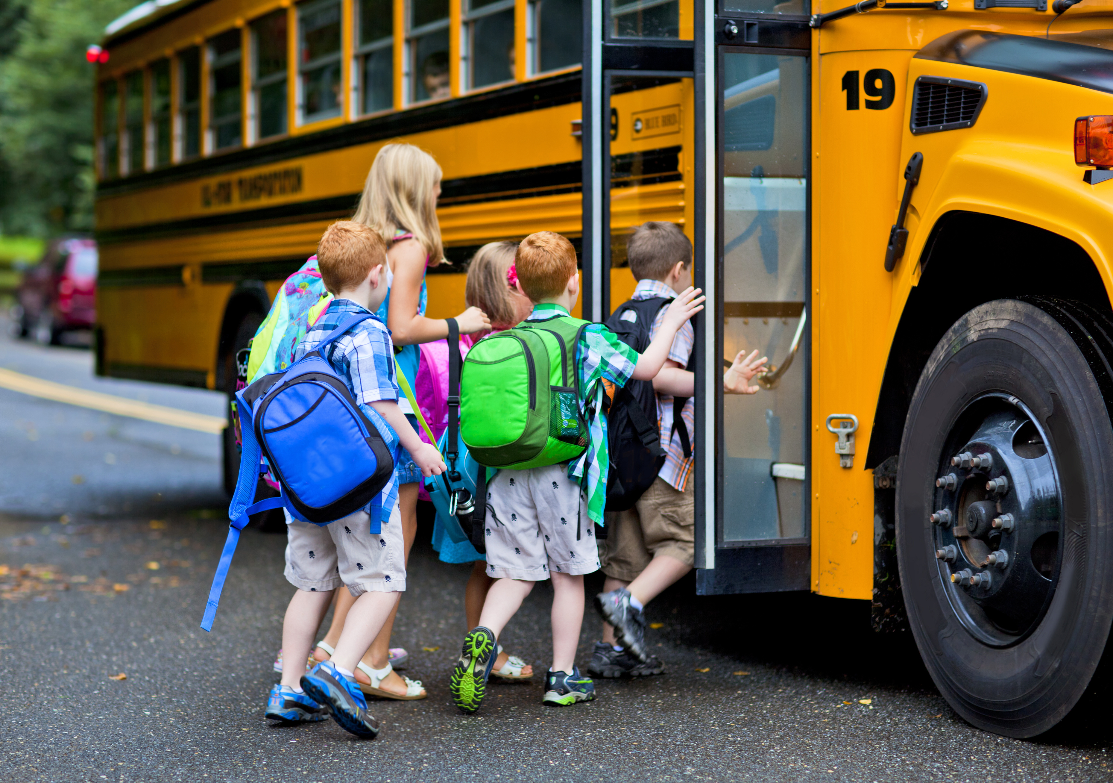 A group of young children getting on the schoolbus