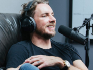 Why Dax Shepard Refuses to High-Five His Kids’ Every Accomplishment (and Other Parenting Practices He Recommends) dax at microphone