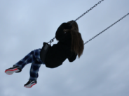 Let’s Pass Some More Free-Range Parenting Laws in 2021! unsplash kid on swing in air noah sillman