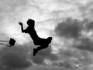 Silhouette of Little Boy Jumping Off Swing